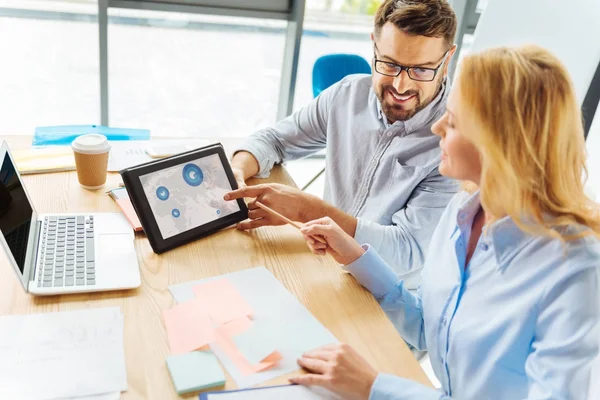 Esmer adam ortağı ile tartışırken gülümseyen