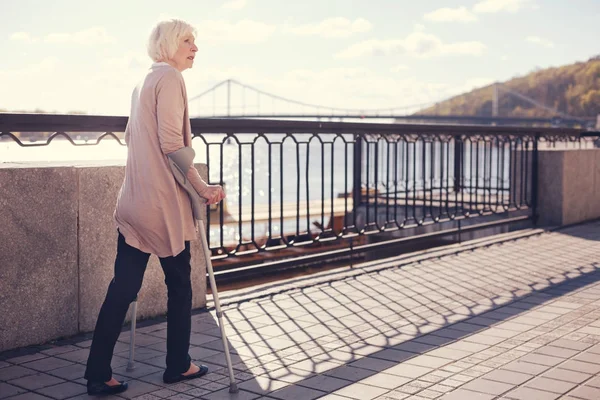 Seniorin geht mit Krücken — Stockfoto