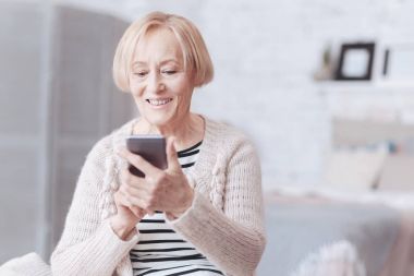 Pozitif fikirli üst düzey Bayan onun smartphone ekranında arıyorum