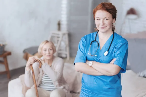 Веселая зрелая медсестра со скрещенными руками — стоковое фото