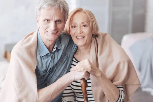 Adorável casal aposentado abraçando e sorrindo para a câmera — Fotografia de Stock