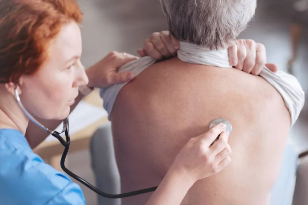 Primo piano del medico che ascolta di nuovo il paziente con stetoscopio — Foto Stock