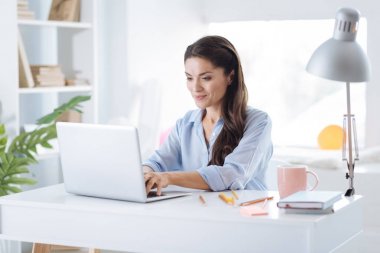 Bir dizüstü bilgisayarda çalışan mutlu güzel kadın