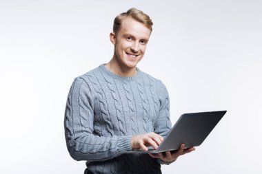 Dizüstü bilgisayarda çalışma gri süveterli yakışıklı adam