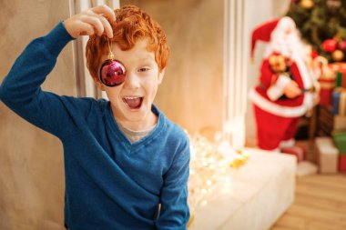 Komik Kızıl saçlı çocuk Noel dekoratif topu ile komik surat