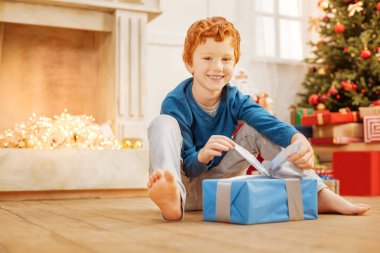 Onun Noel hediye açılış gülen Kızıl saçlı çocuk