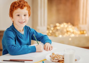 Küçük çocuk Noel Baba'ya mektup yazma heyecanlı