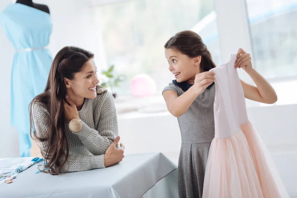 Happy excited girl taking a dress — Stock Photo, Image