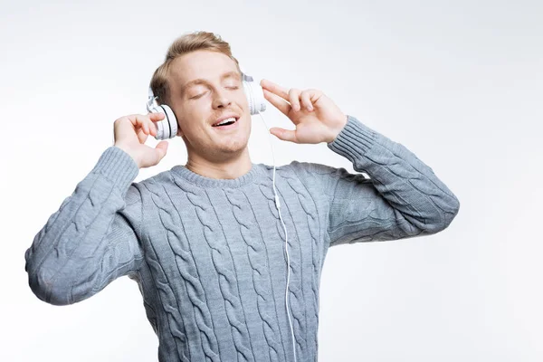 Inspirierter junger Mann genießt Musik im Kopfhörer — Stockfoto