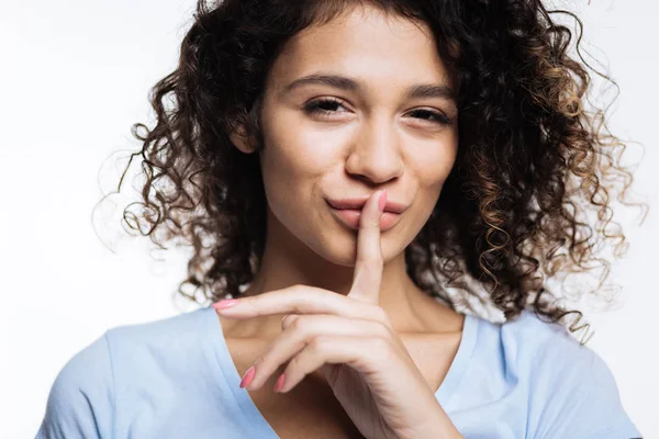 Beautiful curly woman pressing fingers to her lips — Stock Photo, Image