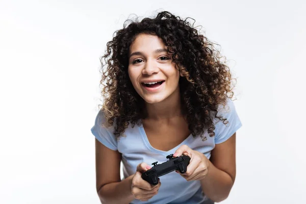 Upbeat rizado mujer de pelo jugando videojuegos —  Fotos de Stock