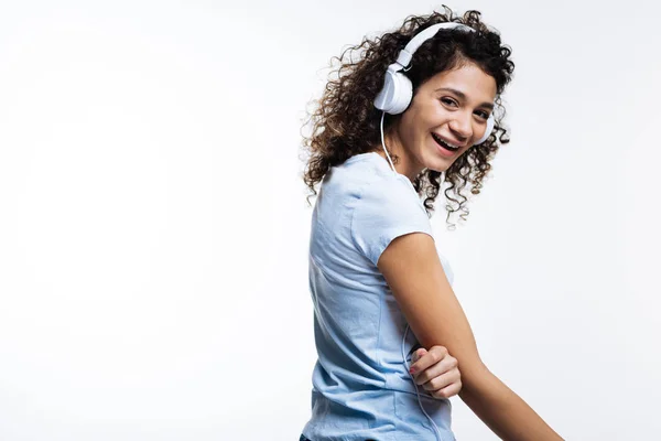 Härlig curly-haired kvinna Lyssna på musik och skratta — Stockfoto