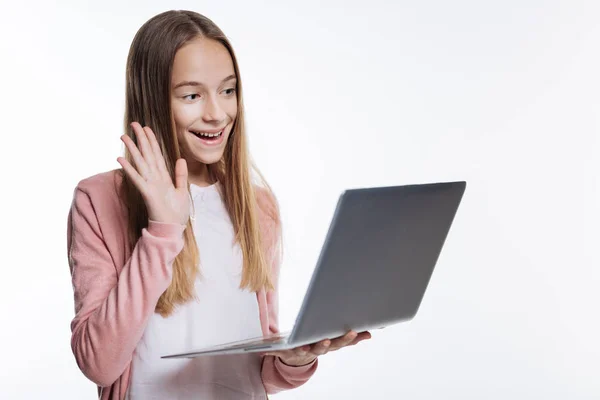 Menina adolescente agradável fazendo uma chamada de vídeo via laptop — Fotografia de Stock