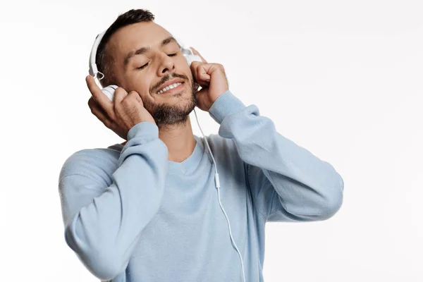 Close up of dark-haired bristled man listening to music — Stock Photo, Image