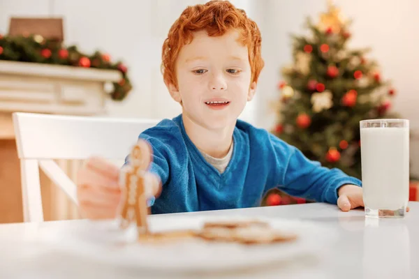 Happy curly haired kid playing with gingerbread man — Stock Photo, Image