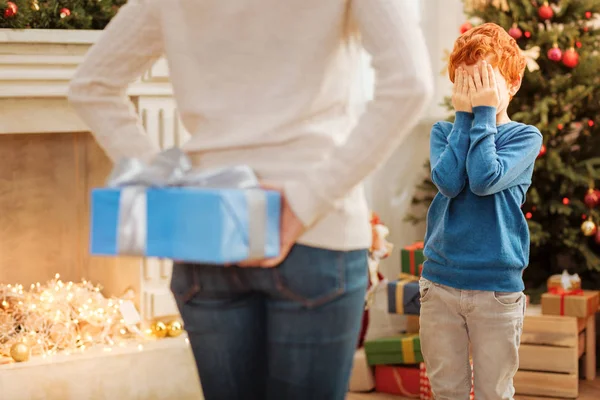 Excited boy closing his eyes while waiting for christmas present — Stock Photo, Image