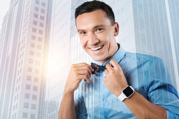 Happy cheerful man holding his bow tie — Stock Photo, Image