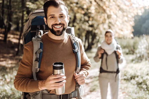 Close up of positive traveller with a thermos bottle — Stock Photo, Image