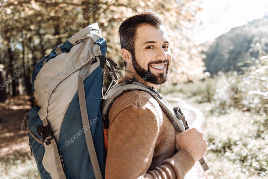 Cheerful handsome man caring a rucksack