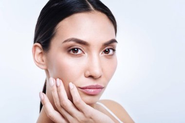 Kara gözlü esmer yanak yakınındaki eliyle poz