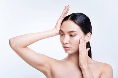 Güzel esmer iki elinizle yüzünü dokunaklı poz