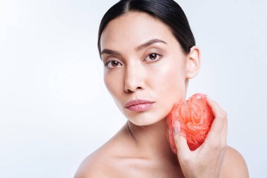 Banyo süngeri boynunu yakınındaki tutan güzel kadın