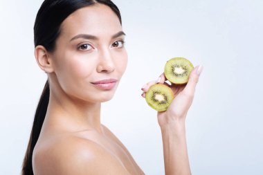 Kivi iki yarısı ile poz çekici esmer kadın