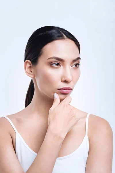 Beautiful young woman touching her chin while posing — Stock Photo, Image