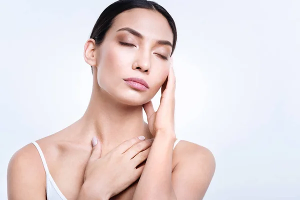 Charming woman closing her eyes and touching her chest — Stock Photo, Image