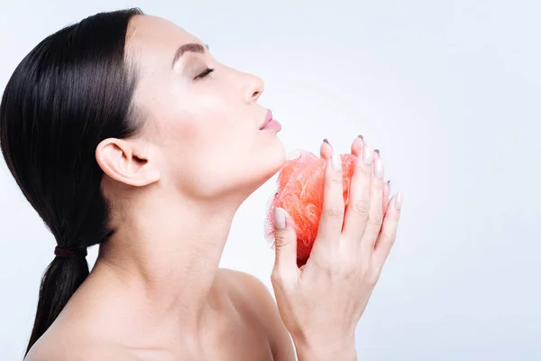 Vista lateral de la hermosa mujer que cuece la esponja del baño en las manos — Foto de Stock