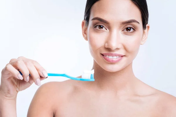 Lächelnde Frau mit Zahnbürste und Zahnpasta darauf — Stockfoto
