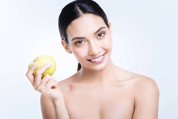 Cheerful woman holding yellow apple — Stock Photo, Image