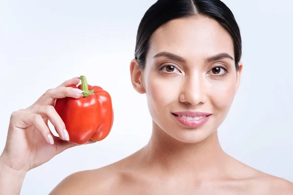 Cheerful young woman showing bell pepper — Stock Photo, Image