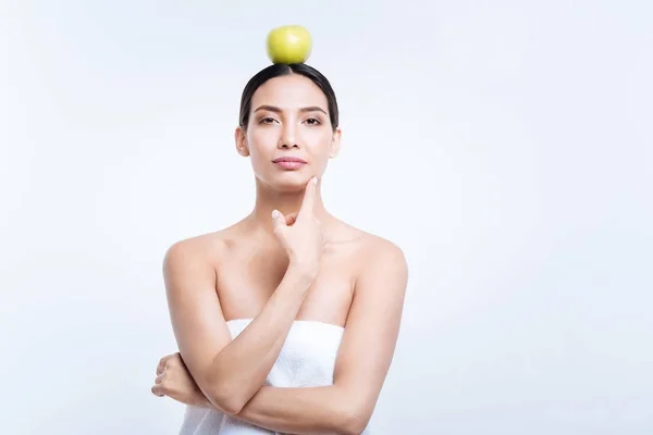 Mujer agradable sosteniendo manzana en su cabeza — Foto de Stock