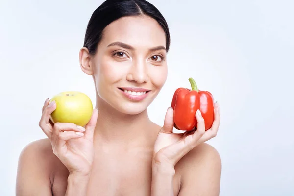 Hymyilevä nainen pippuri ja omena — kuvapankkivalokuva
