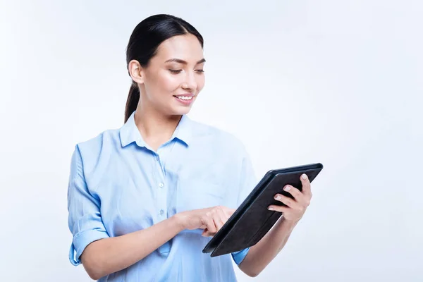 Smiling woman reading messages on her tablet — Stock Photo, Image
