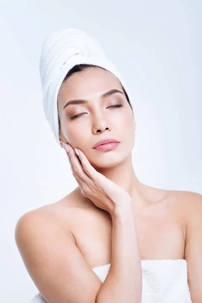 Pleasant woman in towel turban touching her face — Stock Photo, Image