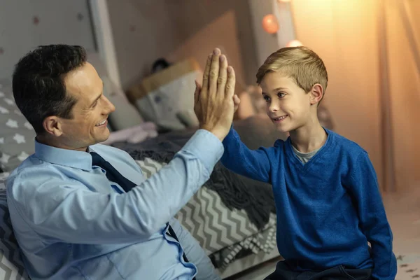 Позитивный восторженный человек, касающийся рук своего сына — стоковое фото