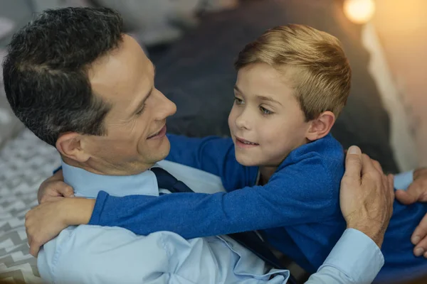 Позитивный отец обнимает своего сына — стоковое фото