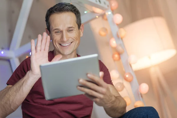 Cheerful male person having online conversation