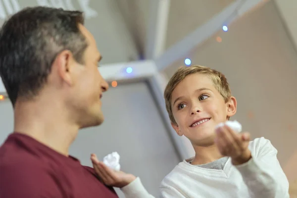 Foto de ángulo bajo del niño sonriente que sostiene la espuma —  Fotos de Stock