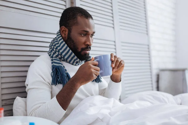 Hombre serio bebiendo té caliente en casa — Foto de Stock