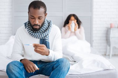 Termometre görünen hasta adam üzgün