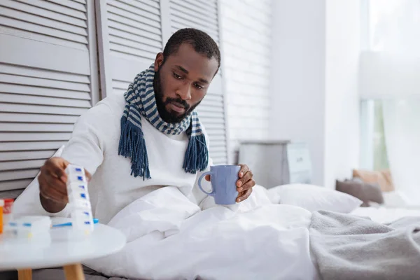Hombre tranquilo tomando sus pastillas mientras está enfermo — Foto de Stock