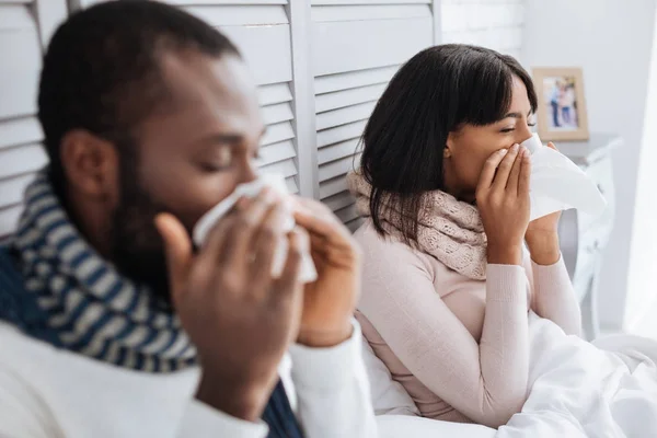 Two ill people sneezing in their bedroom — Stock Photo, Image