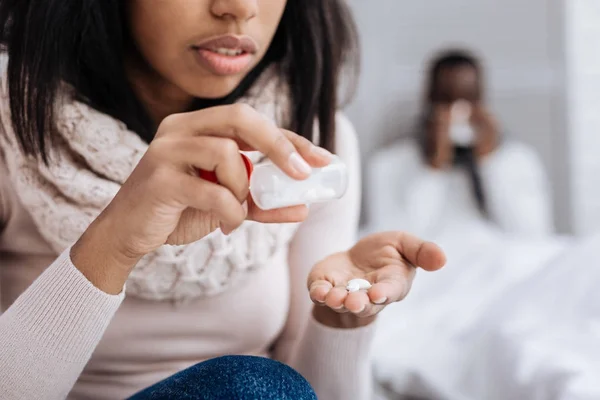 Piccole pillole utili nelle mani di una giovane donna attenta — Foto Stock