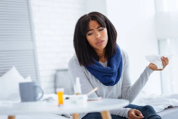 Mujer joven infeliz mirando las pastillas en su mesa — Foto de Stock