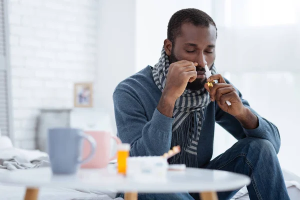 Un homme malade ferme les yeux en utilisant des gouttes spéciales — Photo