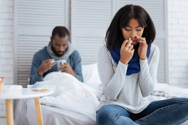 Sorgliga kvinna bota influensa tillsammans med sin pojkvän — Stockfoto