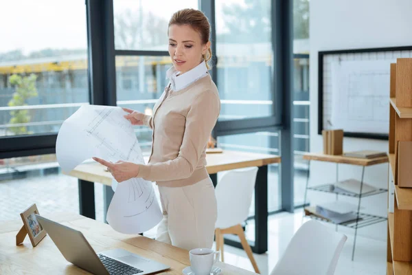 Ingeniero reflexivo sosteniendo un boceto — Foto de Stock